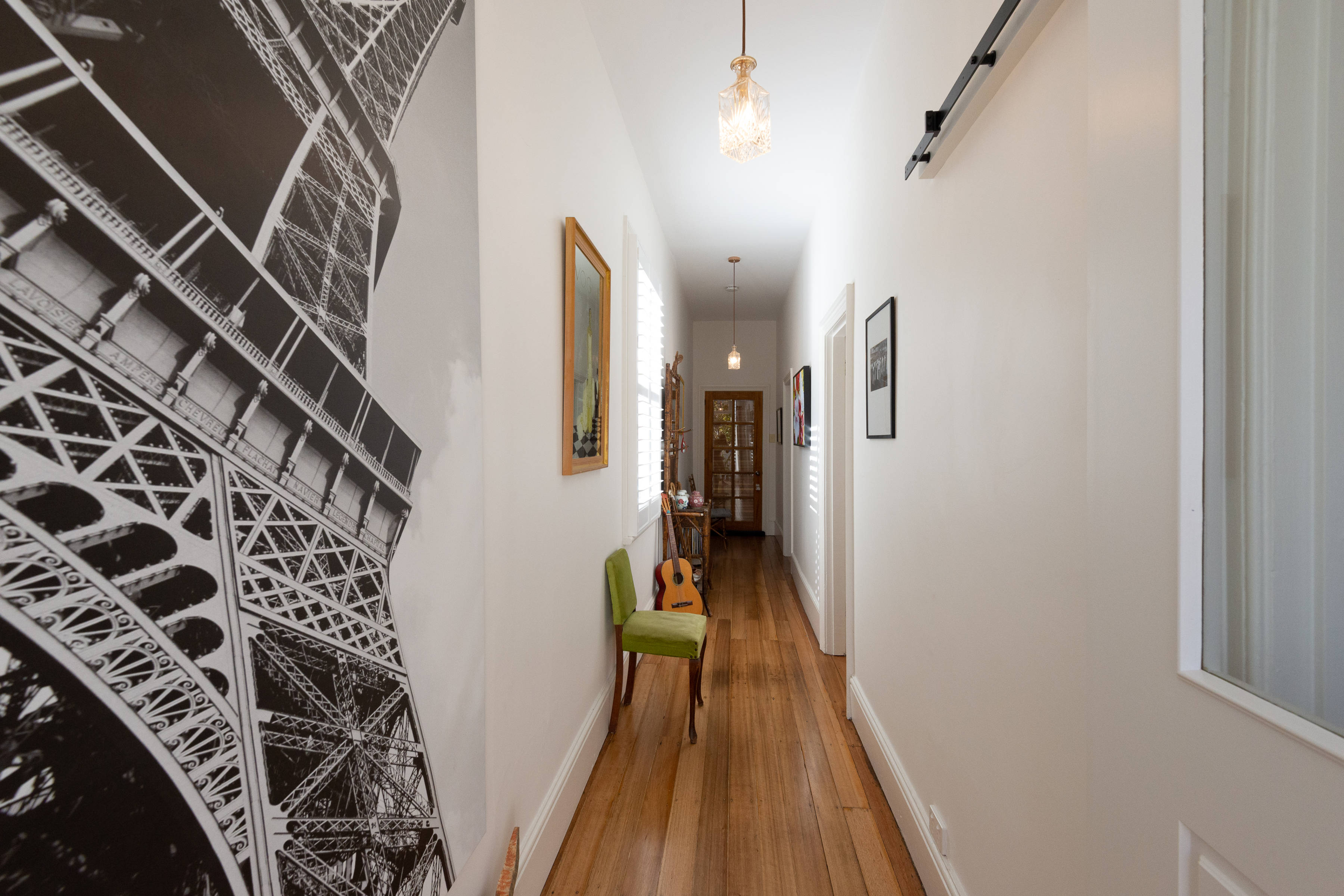 Hallway view from front door, large artwork, wooden floorboards and other ornaments. Photo: Oliver Berlin.