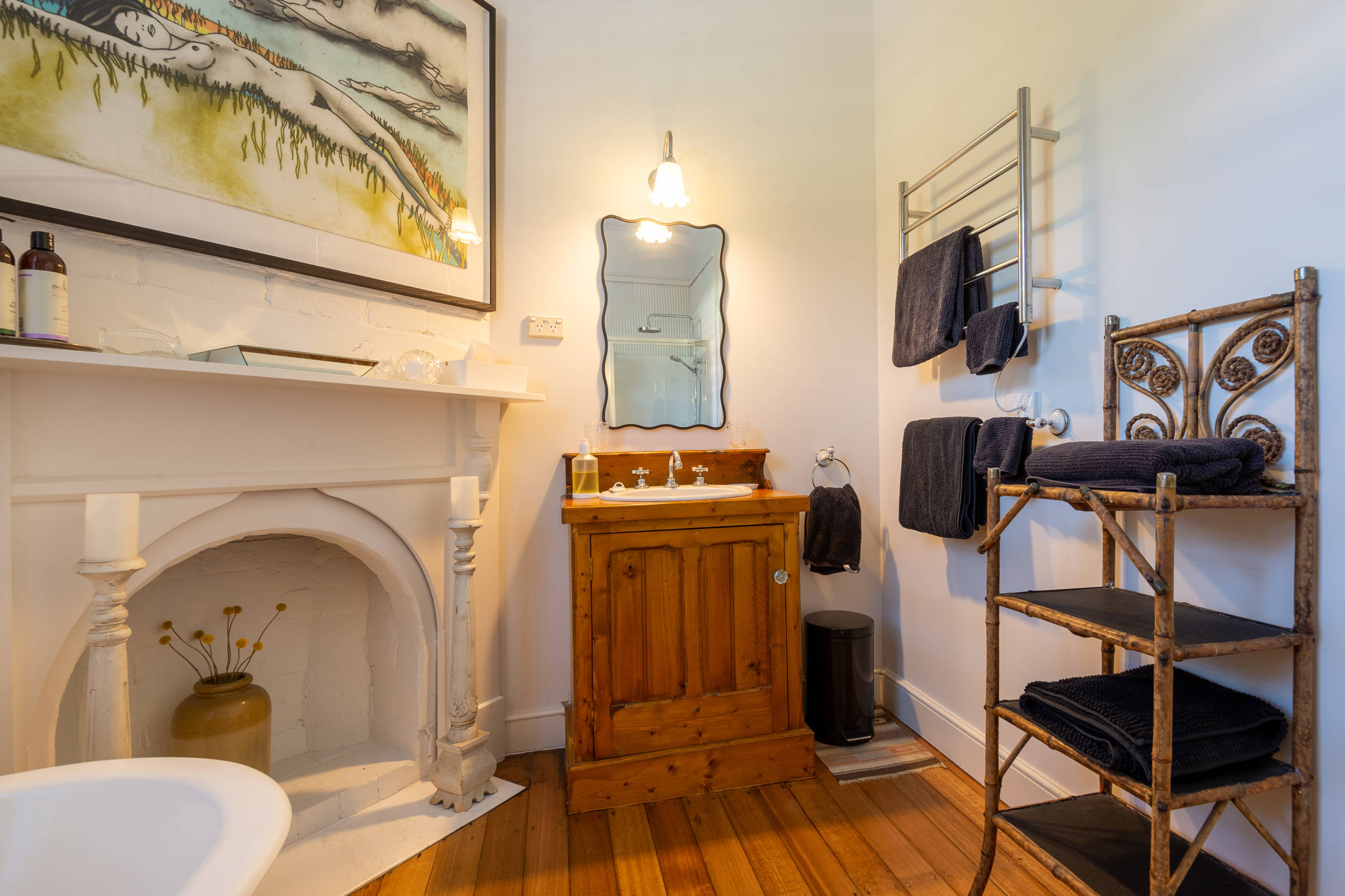 Bathroom showing fireplace, vanity unit, mirror and shelves. Photo: Oliver Berlin.