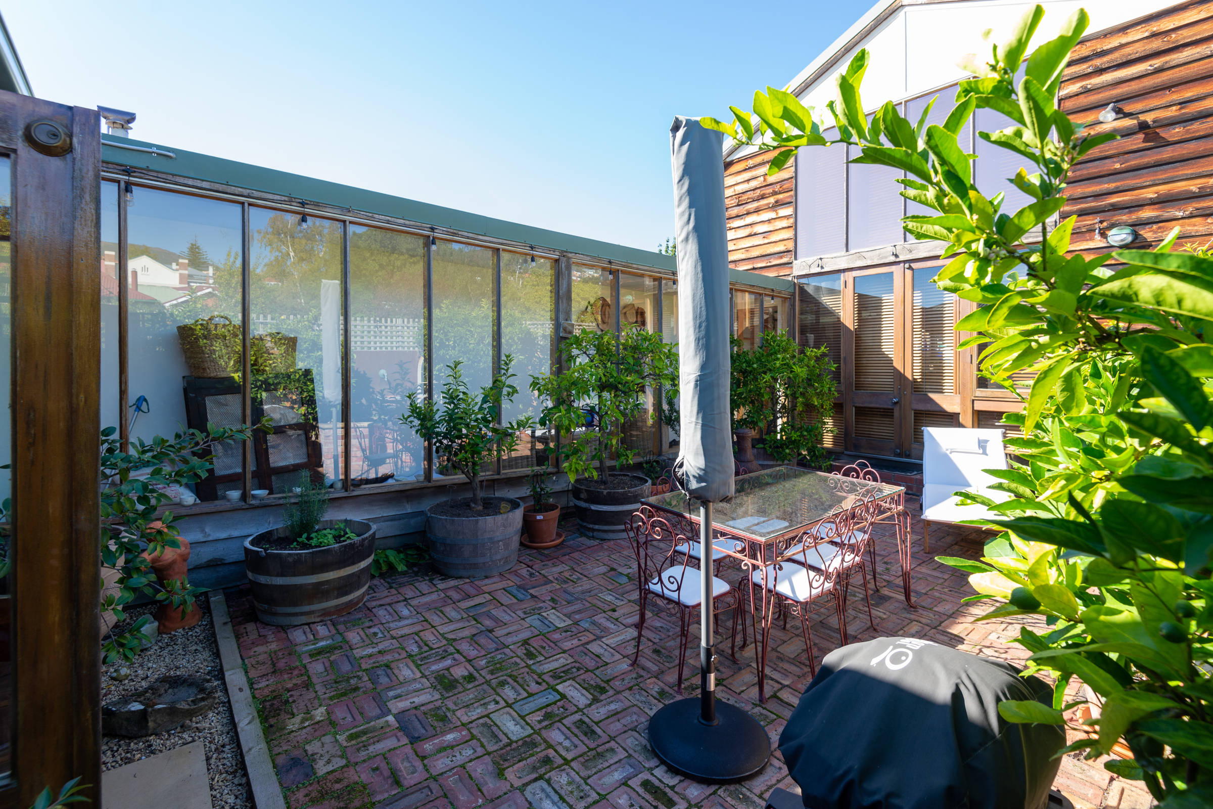 View of courtyard with furniture and fruit trees in barrels. Photo: Oliver Berlin.